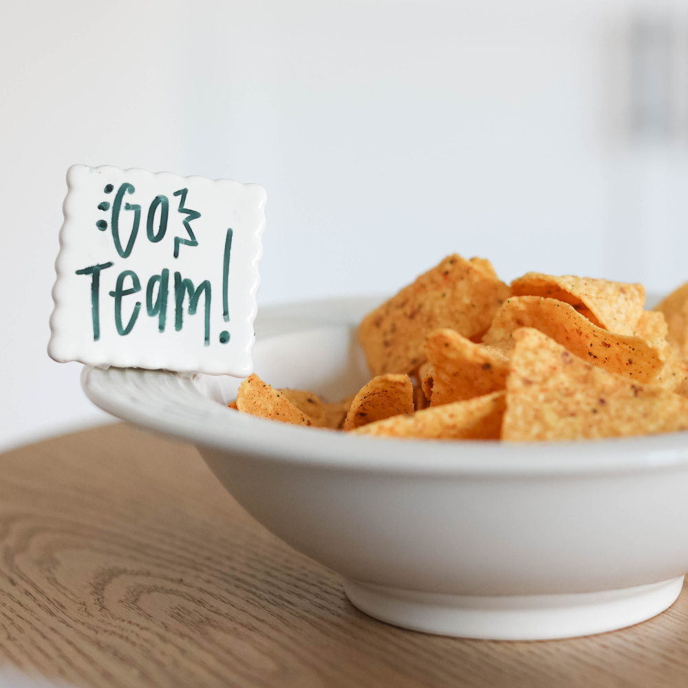 simple scallop to write your message of "go team" on a pinstripes baby bowl filled with chips