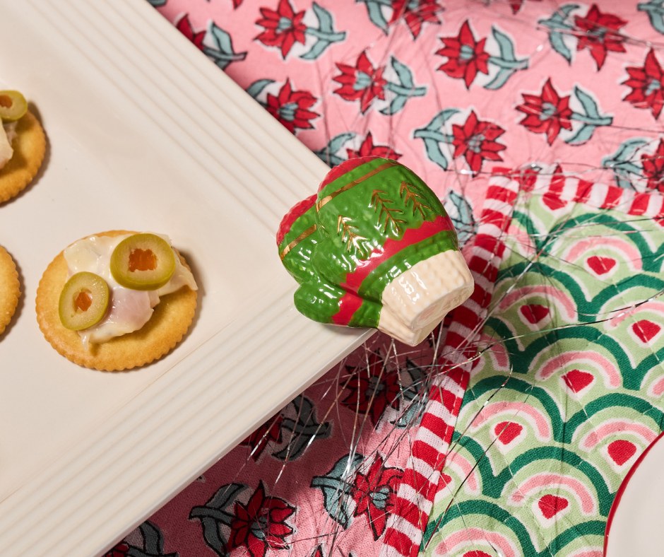 Decorative Christmas-themed mitten mini on a pink floral fabric background