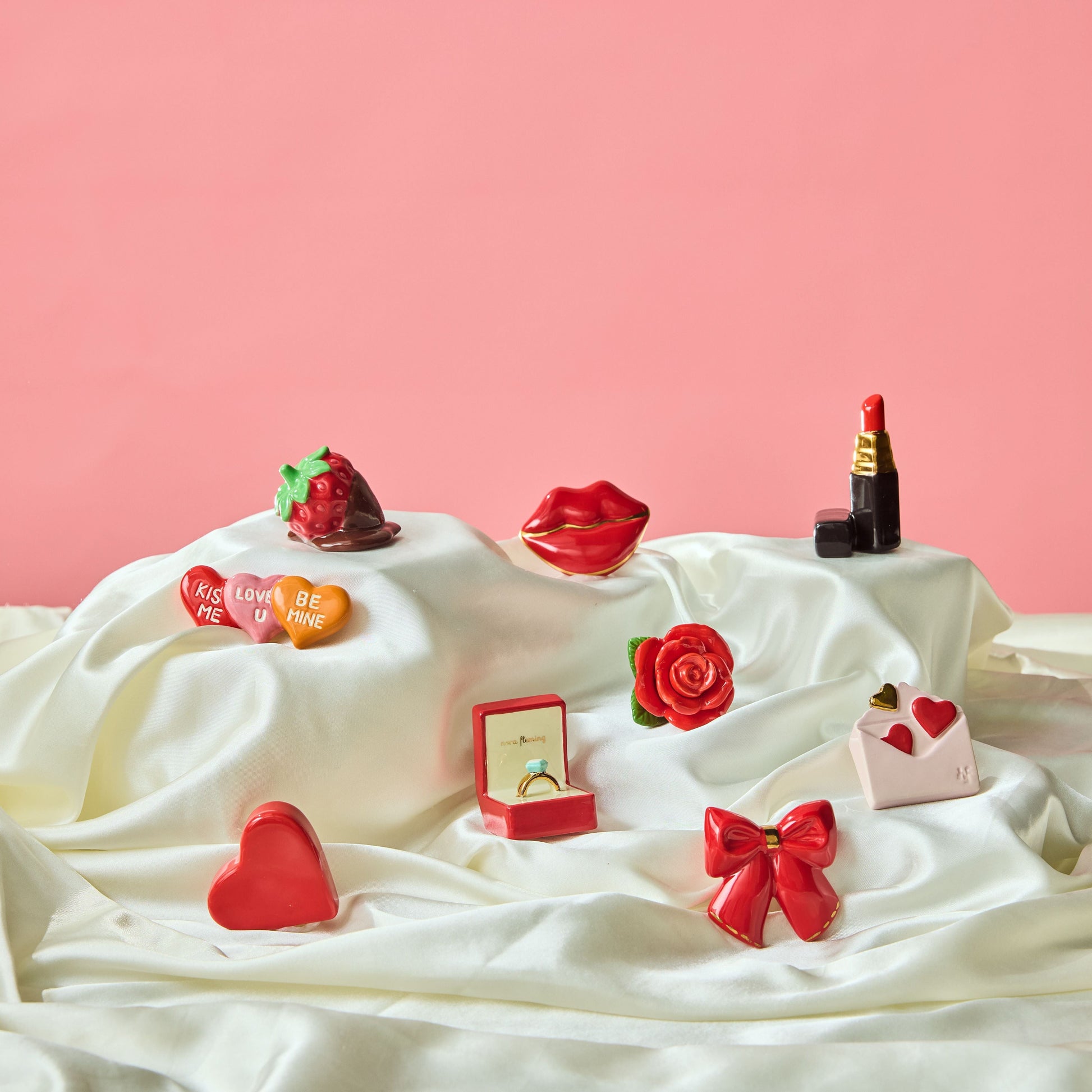 a collection of valentine's day minis on a white satin fabric and pink background