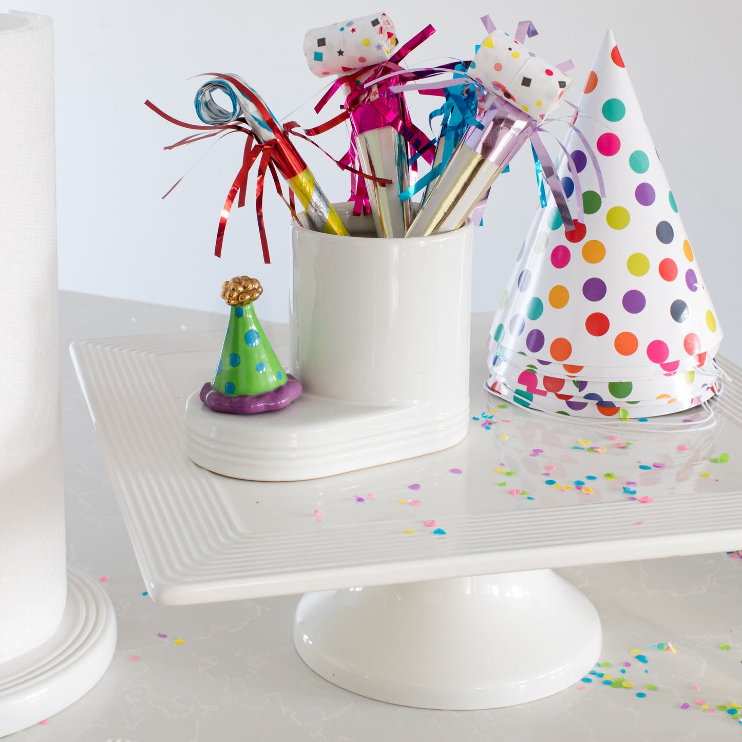 celebration hat on a white cutie container filled with noise makers for a party!