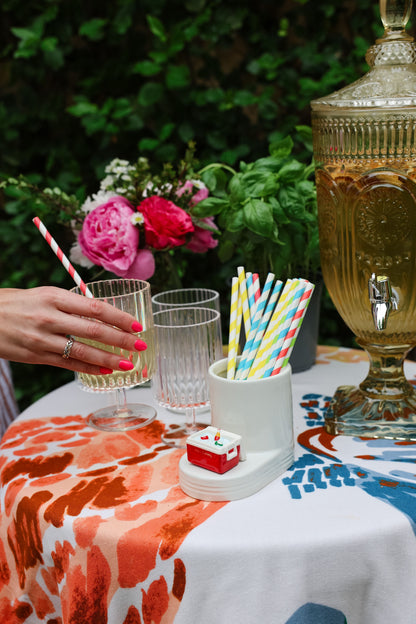Outdoor setting with a tablecloth, glasses, and decorative elements.