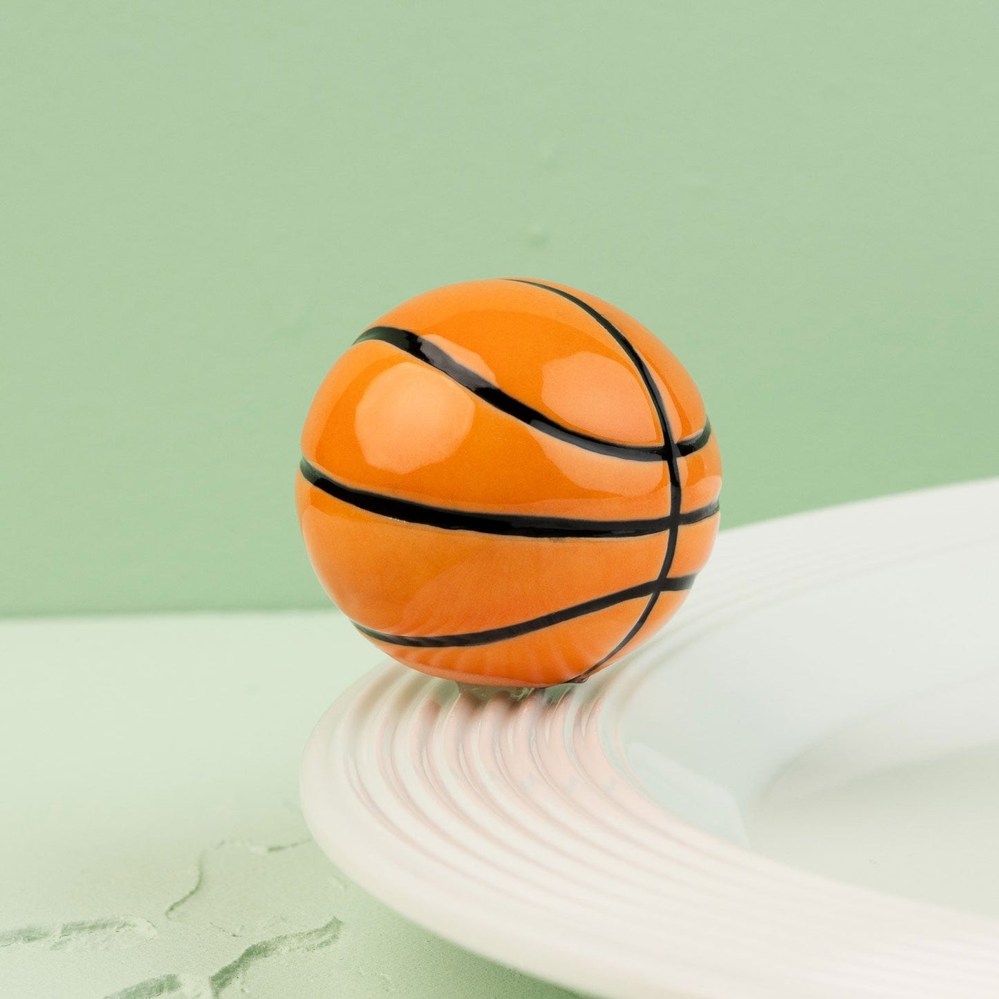 basketball mini on a white surface with a green background