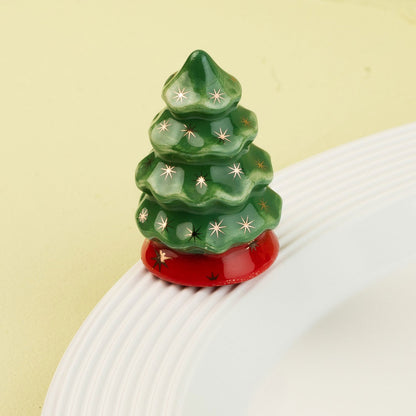 Decorative green Christmas tree mini with star patterns on a white surface and light green background