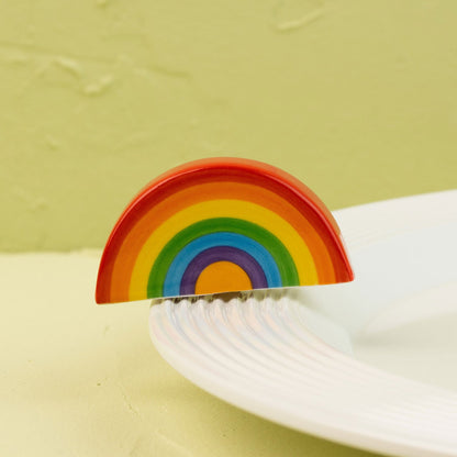Colorful rainbow-shaped mini on a white plate against a light green background