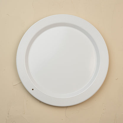 White melamine round platter on a beige background
